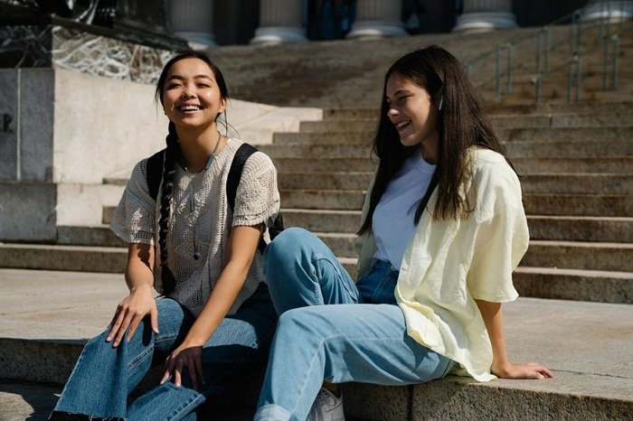 teen girls in White Long Sleeve Shirt Sitting Beside Woman in White T Shirt on steps